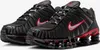 A pair of black Nike Shox TL sneakers with red accents, shown from a slightly elevated front-left angle against a white background. Produktbild-Vorschau