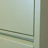 A close-up view of the corner and drawers of a green metal cabinet. Anteprima dell’immagine prodotto