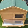 A close-up view of a wooden animal hutch with a green roof and a pull-out tray. Produktbild-Vorschau