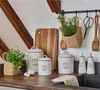 Kitchen counter with storage containers, cutting board, and plants. Produktbild-Vorschau