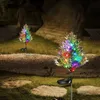 Two solar-powered cypress trees decorated with colorful LED lights are placed in a garden at night. Anteprima dell’immagine prodotto
