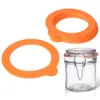 A stack of orange silicone rings and a clear glass jar with a metal clasp. Podgląd zdjęcia produktu
