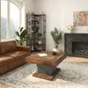 A living room scene with a brown leather sofa, a wooden coffee table, a bookshelf, and a fireplace. Anteprima dell’immagine prodotto