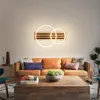 A living room scene with a sofa, coffee table, and a wall-mounted light fixture. Produktbild-Vorschau