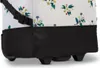 A close-up view of the bottom section of a wheeled bag with a floral pattern. Voir les images du produit