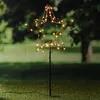 A lighted star decoration is placed on a grassy lawn at dusk. Produktbild-Vorschau