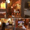 A collage of images showing a miniature DIY book nook kit with cats and furniture. Voir les images du produit