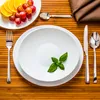 A table setting with plates, cutlery, and fruit. Produktbild-Vorschau
