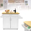 A white kitchen cart with a wooden countertop is shown in a bright, modern kitchen setting. Náhled obrázku produktu