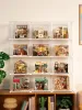 A collection of miniature dollhouse kits displayed in clear acrylic cases on shelves. Podgląd zdjęcia produktu
