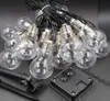 A close-up view of a string of solar-powered LED light bulbs and a solar panel. Produktbild-Vorschau