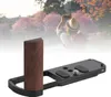 A camera accessory in the foreground with a blurred background of a person taking a photo of a scenic landscape. Podgląd zdjęcia produktu