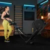 A woman is using an elliptical trainer in a home gym setting. Produktbild-Vorschau