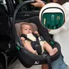 A baby is placed in a car seat that is being held by a person next to a car door. Náhľad obrázku produktu