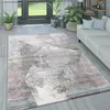 A living room scene with a rug, sofa, and plants.