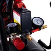 Close-up of an air compressor's control panel, showing pressure gauges, a red emergency stop button, and warning labels. Produktbild-Vorschau
