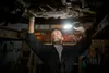 A mechanic is working on the underside of a car in a workshop, using a flashlight to illuminate the area. Anteprima dell’immagine prodotto