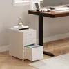A white filing cabinet with three drawers, one of which is open and contains files, sits next to a wooden desk in an office setting. Náhled obrázku produktu