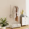 A white children's coat rack with a basket at the bottom, decorated with a bear face at the top. It is placed in a room with a plant and a chest of drawers. Náhled obrázku produktu