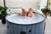 A couple relaxing in an inflatable hot tub indoors. Náhled obrázku produktu