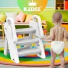 A baby standing in front of a small, multi-step stool in a playroom. Produktbild-Vorschau