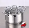 A stainless steel pot with a glass lid sits on a metallic surface, with two red chilies and two garlic cloves in the foreground. Náhľad obrázku produktu