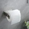 A toilet paper holder mounted on a gray tiled wall, with a roll of toilet paper on it. Produktbild-Vorschau