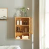 A wooden bathroom cabinet mounted on a gray wall, filled with various toiletries and decorative items. Podgląd zdjęcia produktu