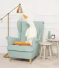 A plush goose toy is sitting in a light blue armchair next to a floor lamp and small side tables. Podgląd zdjęcia produktu