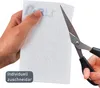 A hand is holding a white filter material and a pair of scissors is about to cut it. Produktbild-Vorschau