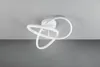 A white, abstract-shaped LED ceiling light is mounted on a light gray ceiling. Podgląd zdjęcia produktu