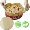 A person is placing a round parchment paper liner into a red springform cake pan with a cake inside. Anteprima dell’immagine prodotto