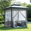 A gazebo with sheer curtains, outdoor furniture, and a table set up in a garden. Voir les images du produit