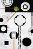 A collection of black and white patterned plates arranged on a textured background. Produktbild-Vorschau