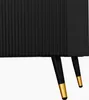 A close-up view of the bottom part of a black sideboard with gold accents on its legs. Podgląd zdjęcia produktu