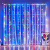 A curtain of colorful LED lights hangs in front of sheer white curtains, illuminating the room with a vibrant glow. Podgląd zdjęcia produktu
