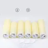 Six cream-colored LED candles are lined up and connected by white charging cables. Voir les images du produit