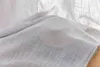 A close-up of a light gray, semi-transparent fabric with a woven texture, likely a curtain. Produktbild-Vorschau