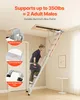 A man is climbing an attic ladder that is extended from an opening in the ceiling. Anteprima dell’immagine prodotto