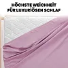 A close-up view of a pink fitted sheet draped over a mattress. Produktbild-Vorschau