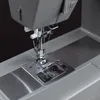 A close-up view of the needle and presser foot of a sewing machine. Náhled obrázku produktu