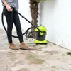 A person is using a wet and dry vacuum cleaner outdoors next to a palm tree and a white wall. Anteprima dell’immagine prodotto