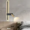 A modern bedroom setting with a wall lamp above a nightstand and bed. Produktbild-Vorschau