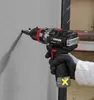 A person is using a cordless drill to make a hole in a wall. Produktbild-Vorschau