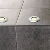 A close-up view of two recessed floor lights embedded in a tiled floor. Produktbild-Vorschau