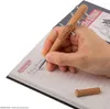 A hand is writing in a notebook with a "Stranger Things" themed pen. Produktbild-Vorschau