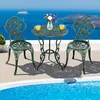 A bistro set with two chairs and a table is placed on a patio next to a swimming pool, with a scenic ocean view in the background. Podgląd zdjęcia produktu