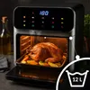 A large air fryer with a roasted chicken and vegetables inside, with steam rising from the top. Produktbild-Vorschau