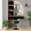 A vanity table with a mirror, shelves, and drawers, set up in a room with plants and a stool. Voir les images du produit