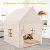 A child's play tent shaped like a house, set up indoors on a carpeted floor. It contains stuffed animals and flower-shaped cushions. Produktbild-Vorschau